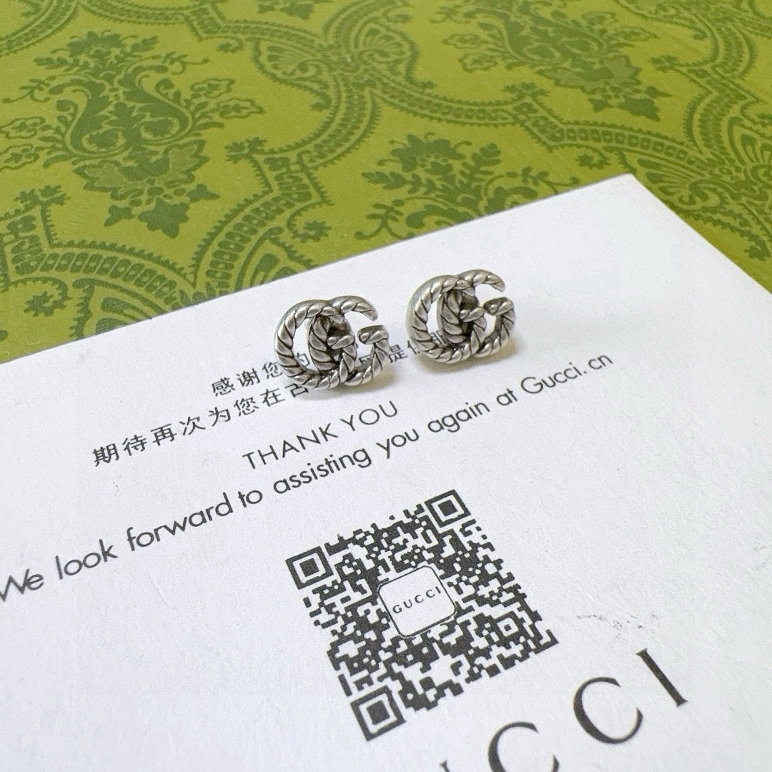 Martin Graham stud earrings in polished metal-tone – detail view
