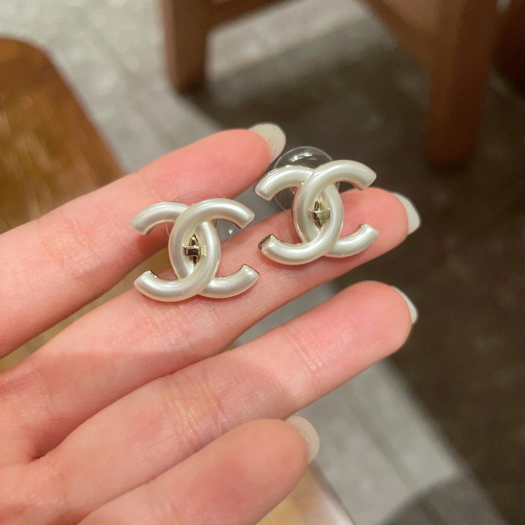 Martin Graham stud earrings in polished metal-tone – close-up detail