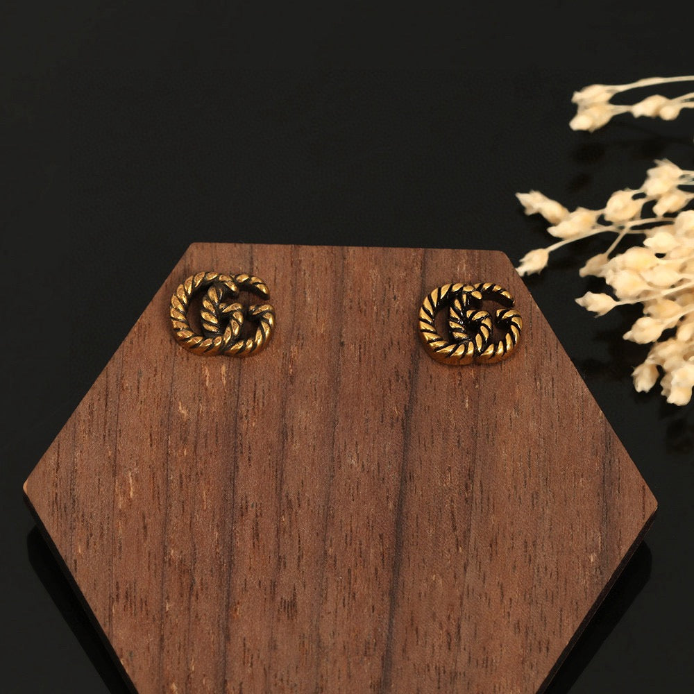 Martin Graham stud earrings in polished metal-tone – close-up detail