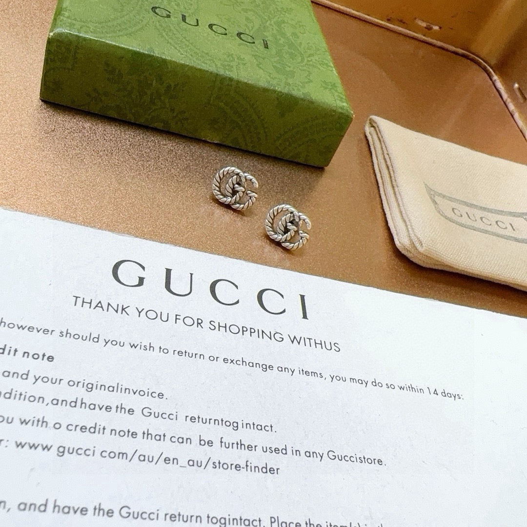 Martin Graham stud earrings in polished metal-tone – close-up detail