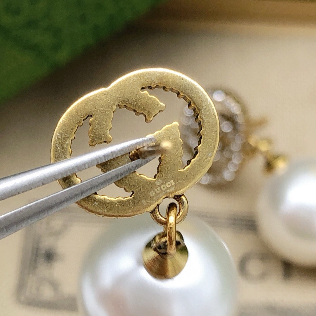 Martin Graham stud earrings in polished metal-tone – close-up detail