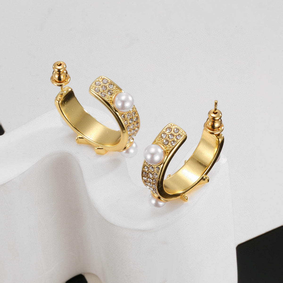 Martin Graham stud earrings in polished metal-tone – close-up detail