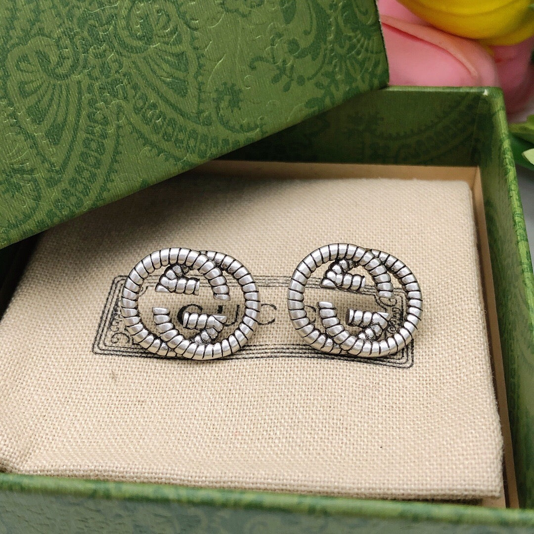 Martin Graham stud earrings in polished metal-tone – close-up detail