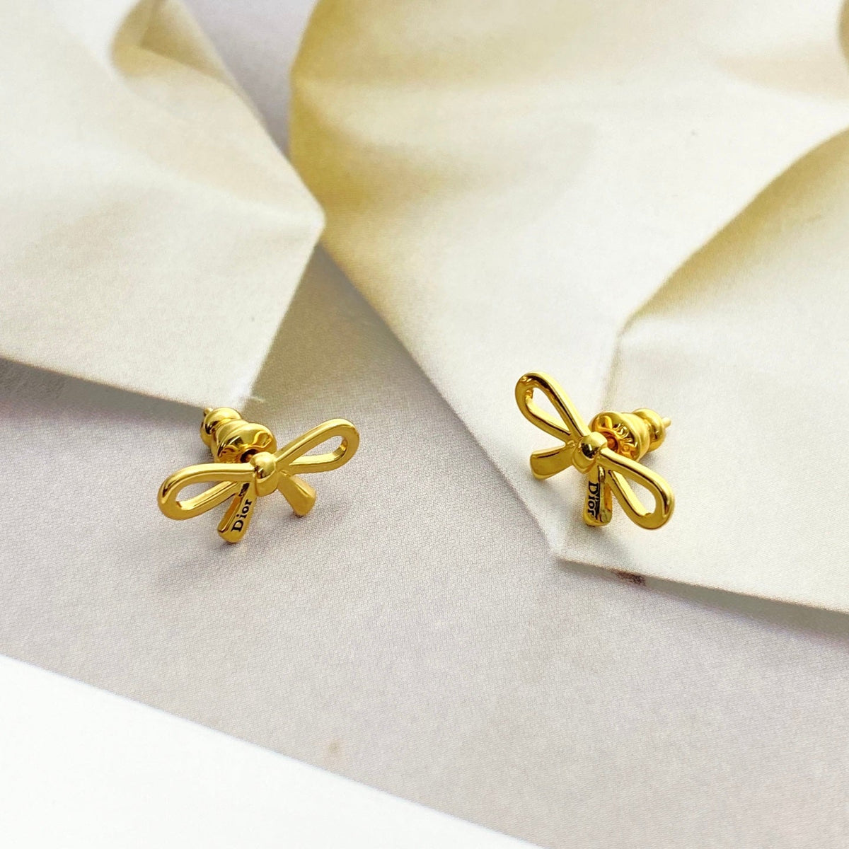 Martin Graham stud earrings in polished metal-tone – close-up detail
